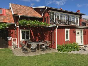 Källby琴纳库勒冒险农场旅馆的院子里的红色房子,配有桌椅