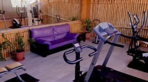 英格兰海滩Bungalows Los Almendros - Exclusive Vacation Club的一间带紫色沙发的客厅和一个健身房