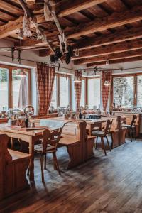 圣恩吉玛Berggasthof Hochpröller的餐厅设有木桌、椅子和窗户。