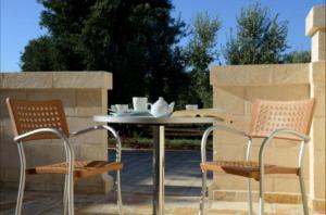 萨维勒特里Agriturismo Masseria San Leonardo的庭院里设有两把椅子和一张桌子