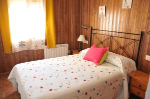 阿罗约弗里奥Alojamientos Rural Tejerina的一间卧室配有一张带粉红色枕头的床