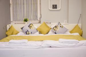 毛科Centrum Luxus Apartman的一张黄色和紫色枕头的床