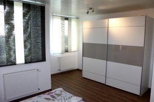 威克贝格Fewo Weitsicht的一间设有白色大橱柜和窗户的客房