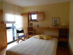 维拉·普拉亚·德·安科拉Casa do Murungal的卧室配有床、椅子和窗户。