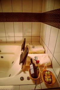 QuillabambaEcolodge Don Felix的浴缸、两张床和两瓶葡萄酒