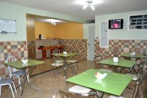 马卡埃Pousada Alto Riviera的一间在房间内配有桌椅的餐厅