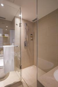 台北和逸饭店．台北忠孝馆的一间带玻璃淋浴和卫生间的浴室