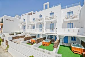 阿吉奥斯普罗科皮奥斯纳克索斯岛酒店的一座白色的大建筑,前面有一个绿色的草坪
