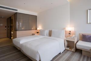 台北和逸饭店．台北忠孝馆的卧室配有一张白色的大床和一张沙发。
