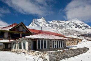 KongdeMountain Lodges of Nepal - Kongde的雪覆盖的山前的房子