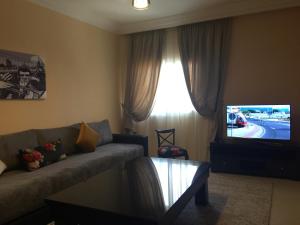 达赫拉Résidence Tamaya的带沙发和电视的客厅