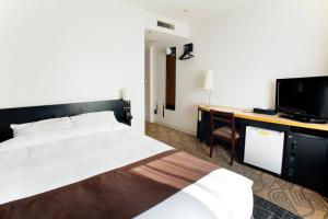 札幌札幌东急REI酒店的一间卧室配有一张床、一张书桌和一台电视
