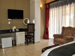 Sibasa2Ten Hotel的一间卧室配有一张床、一张桌子和一把椅子