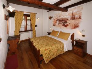 萨奥兹-杜尔克斯澈欧斯旅游木屋酒店的卧室配有一张床,墙上挂有绘画作品