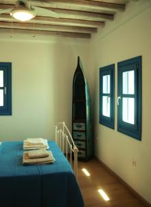 基斯诺斯Almyra Yellow Villa的一间卧室设有蓝色的床和2个窗户。