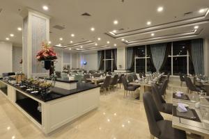 日惹Grand Keisha Yogyakarta的一间在房间内配有桌椅的餐厅