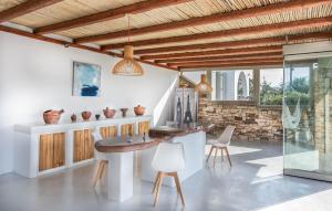 纳克索乔拉Halcyon Suites and Villas Naxos的配有桌椅和石墙的房间