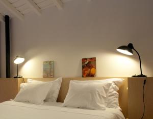 科英布拉科英布拉老式阁楼公寓酒店的一间卧室配有一张带白色枕头的床和两盏灯。