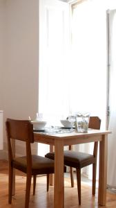 科英布拉科英布拉老式阁楼公寓酒店的一张带两把椅子的木桌和一张带眼镜的桌子