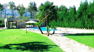 维拉·雷阿尔Casa Do Prado Guesthouse的一个带游泳池和房子的庭院