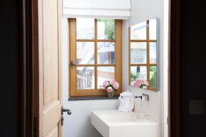 Surville叙尔维尔庄园的一间带水槽和镜子的浴室以及窗户。