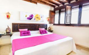 格拉纳达Casa de Federico Boutique的一间卧室配有一张带紫色枕头的大床