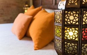 格拉纳达Casa de Federico Boutique的一张带橙色枕头和蜡烛的床