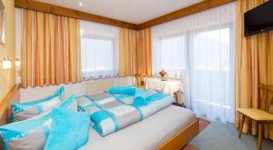 索尔登盖思福格兰斯汀膳食旅馆的一间卧室配有一张带蓝色枕头的大床
