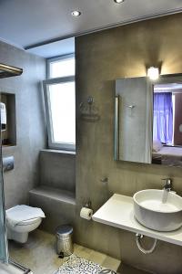 波利伊罗斯Melina Hotel - Central的一间带水槽、卫生间和镜子的浴室