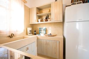 法拉萨纳Mera Beachfront House - Falasarna的厨房配有木制橱柜和白色冰箱。