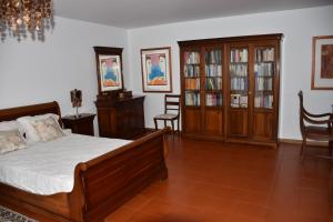 卡罗拉Caloura Camellia House的卧室配有一张床、木制家具和椅子