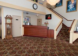 Hampton Falls汉普顿瀑布酒店的一间设有楼梯和墙上时钟的房间