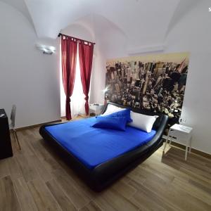 瓦里格提Suite Varigotti的一间卧室配有蓝色的床和红色窗帘
