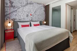 杜伊斯堡杜伊斯堡城际酒店的卧室配有一张大床,墙上挂有地图