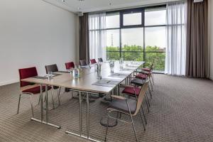 杜伊斯堡杜伊斯堡城际酒店的大型会议室,配有长桌子和椅子
