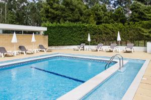 圣玛丽亚大德费拉波尔图扎欧陆公园宜必思酒店 的一个带躺椅的游泳池和一个游泳池