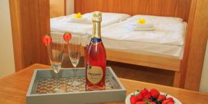 特尔乔夫Hotel Gold的一瓶香槟和一张桌子上的两杯酒