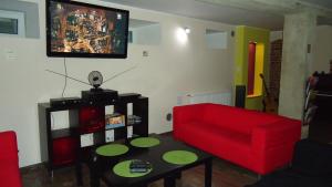 格但斯克La Guitarra Hostel Gdańsk的客厅配有红色的沙发和桌子
