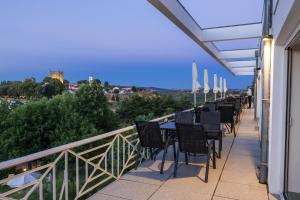 布拉干萨布拉干萨望厦宾馆 - 圣巴托洛梅乌的阳台上的一排桌椅