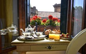 威尼斯科特罗莎酒店的阳台上的桌子上放着食物和茶