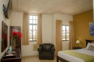 戴维塞万提斯酒店的一间卧室配有一张床、一把椅子和窗户。