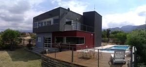 门多萨Terrazas de la Quinta - Cabañas de Montaña的一座带甲板和游泳池的房子