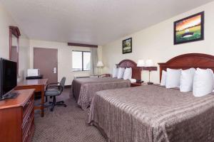 奥古斯塔Heritage Inn Augusta的酒店客房设有两张床、一张桌子和一台电视。