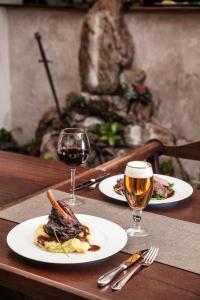 摩拉瓦特热博瓦神剑旅馆及餐厅的一张桌子,上面放着两盘食物和两杯葡萄酒
