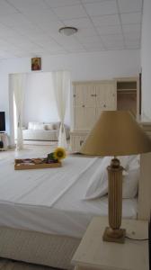 克鲁舒纳奥格尔宾馆的一间白色的大卧室,配有一张带灯的大床