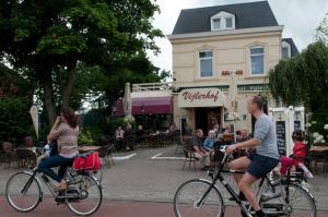 费伦非勒尔豪夫酒店餐厅的几人骑着自行车沿着街道走