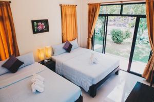 Damnoen Saduak班兰可龙度假村的一间卧室设有两张床和大窗户