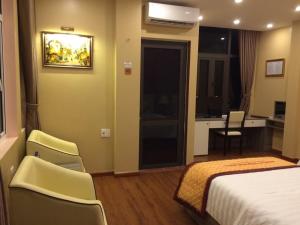 奠边府市宏基精品酒店的酒店客房配有一张床、椅子和一张书桌