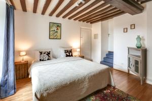 Bons-Tassily城堡乡间杜尔哥渡假屋的一间卧室设有一张大床和一个壁炉