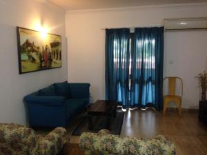 阿伯来Pool and Garden Facing Apartment in Riviera Foothills Near Baga, Arpora的客厅配有蓝色的沙发和桌子